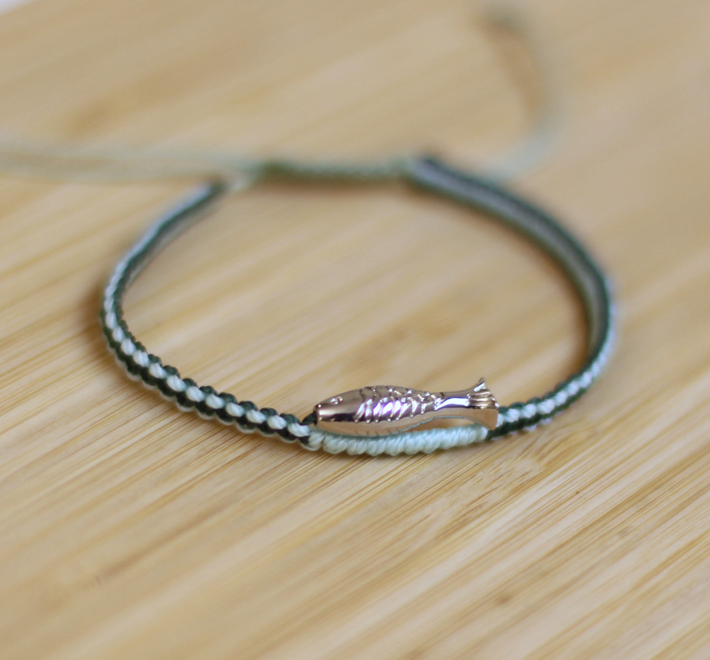 Green and blue bracelet with a silver plated fish