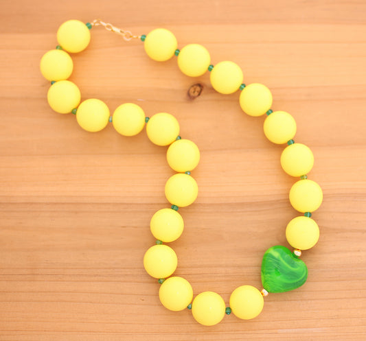Yellow round beads necklace with green heart charm