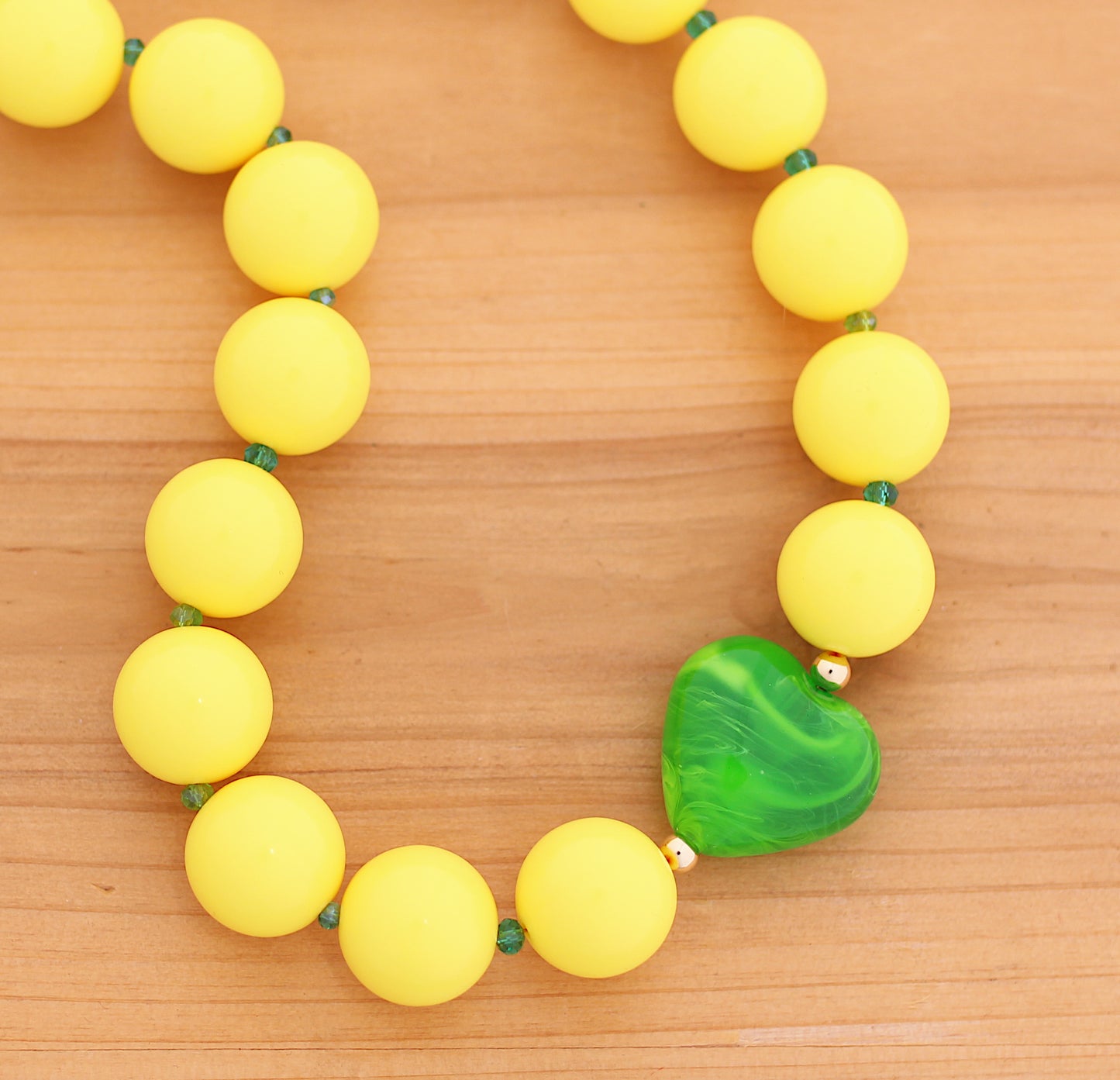 Yellow round beads necklace with green heart charm