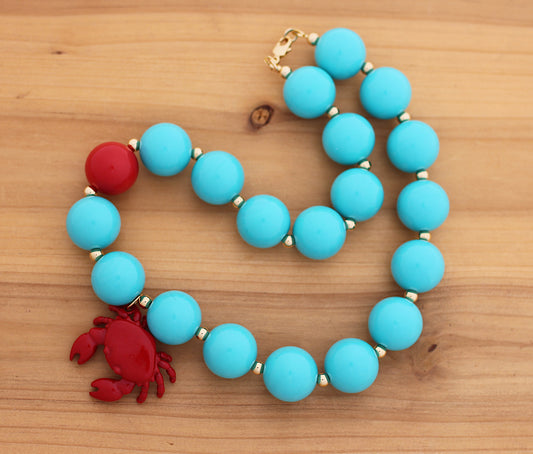 Blue and red necklace with a crab charm