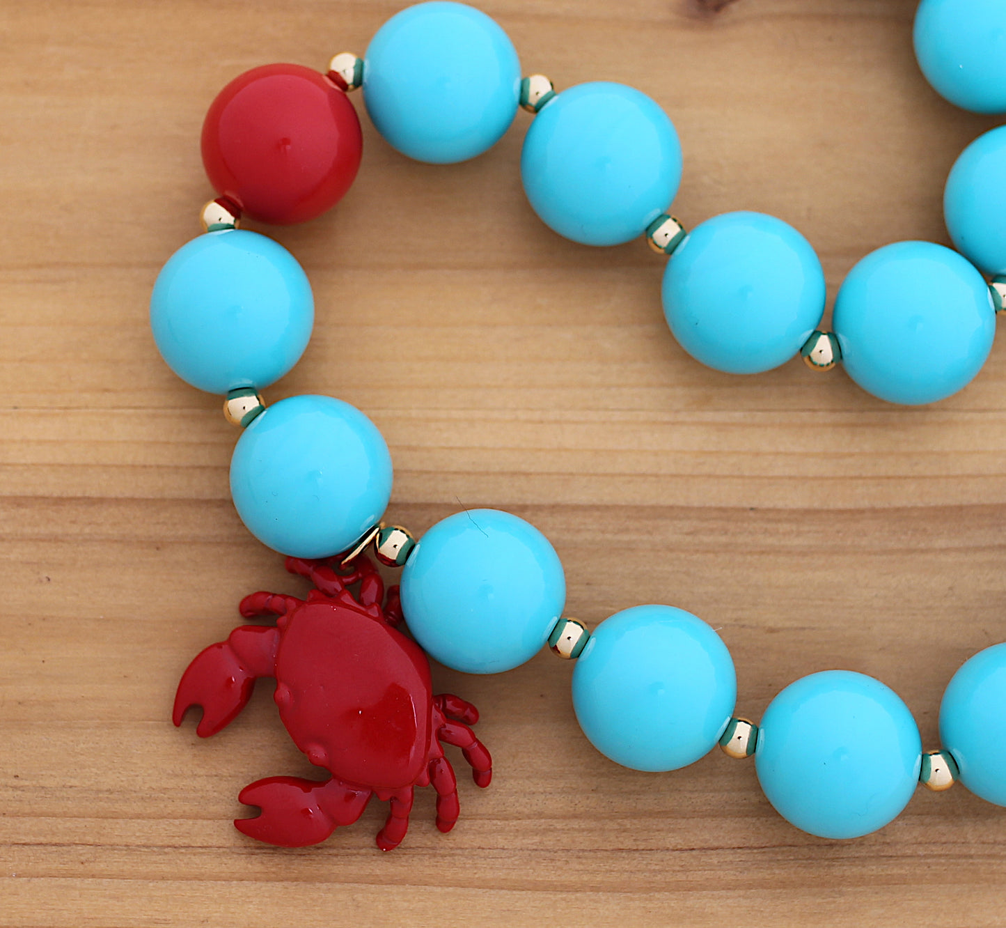Blue and red necklace with a crab charm
