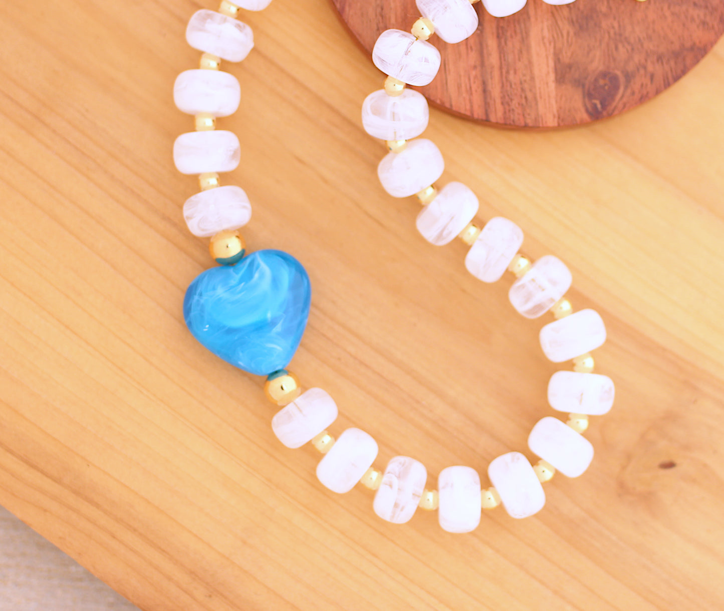 White marbleized donut shape necklace with blue heart